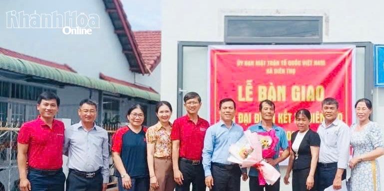 Lãnh đạo xã Diên Thọ và các nhà tài trợ bàn giao nhà và tặng hoa chúc mừng gia đình ông Huỳnh Minh Tiến.