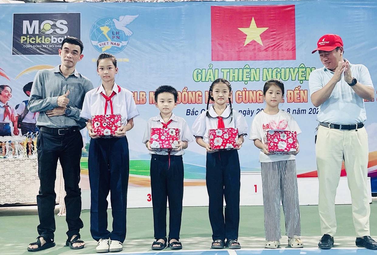Các mạnh thường quân trao quà cho các em học sinh.