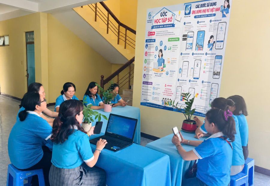 Hội viên phụ nữ tham gia góc học tập số đang cài đặt ứng dụng trên điện thoại