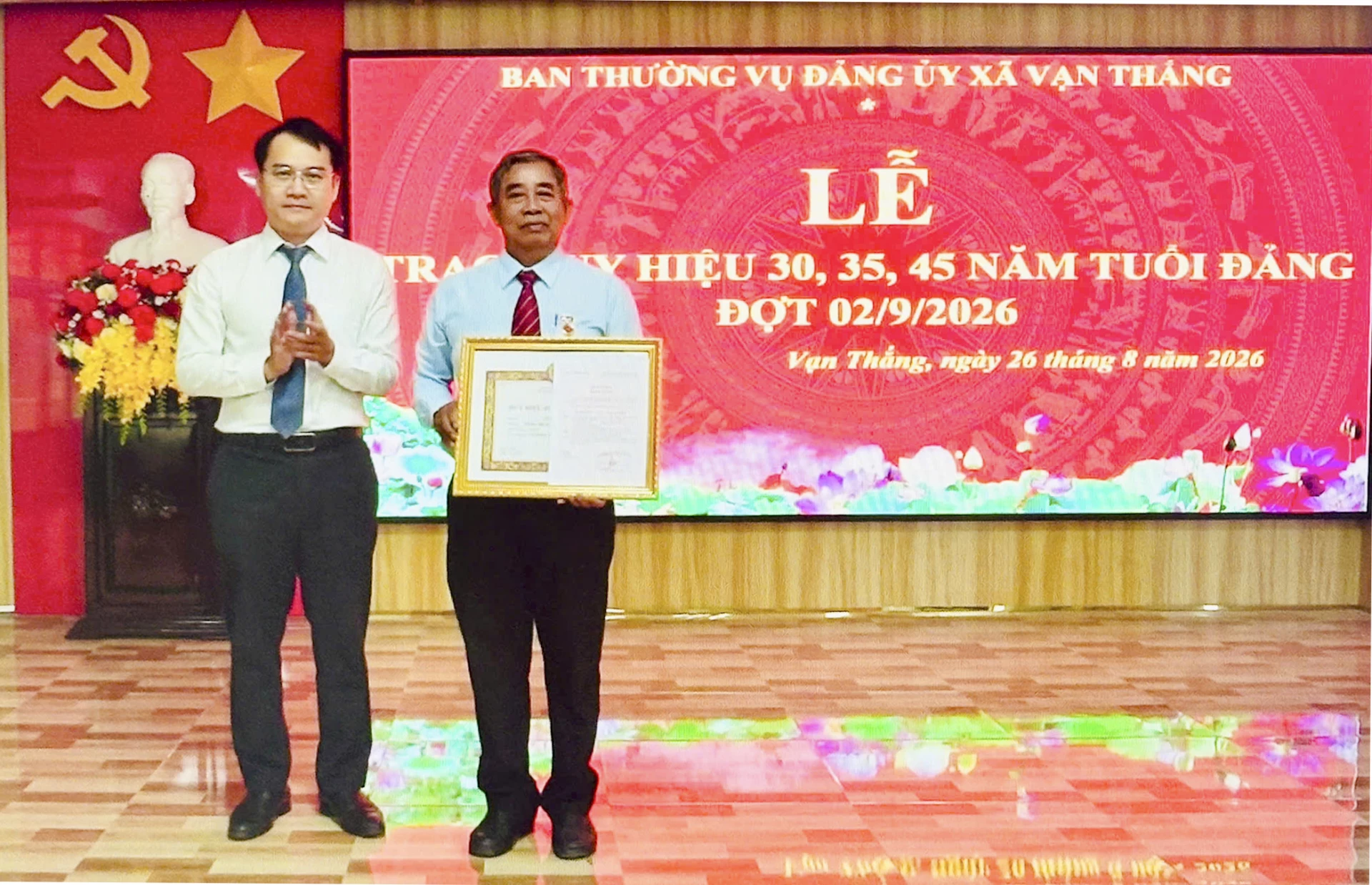 Ông Mai Hữu Bảo Huy – Bí thư Đảng ủy xã Vạn Thắng trao Huy hiệu 45 năm tuổi Đảng cho Đảng viên Lê Văn Khải (Chi bộ thôn Trung Dõng 1).