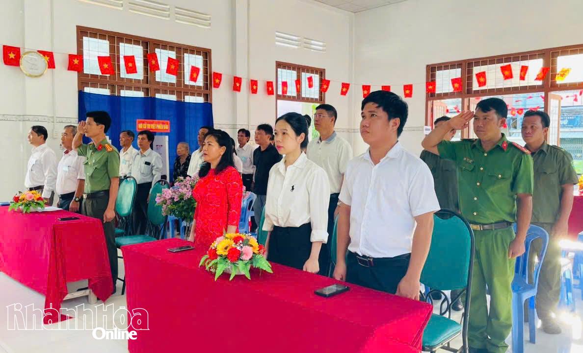 Các đại biểu và cử Tổ dân phố Khánh Sơn thực hiện nghi thức chào cờ.