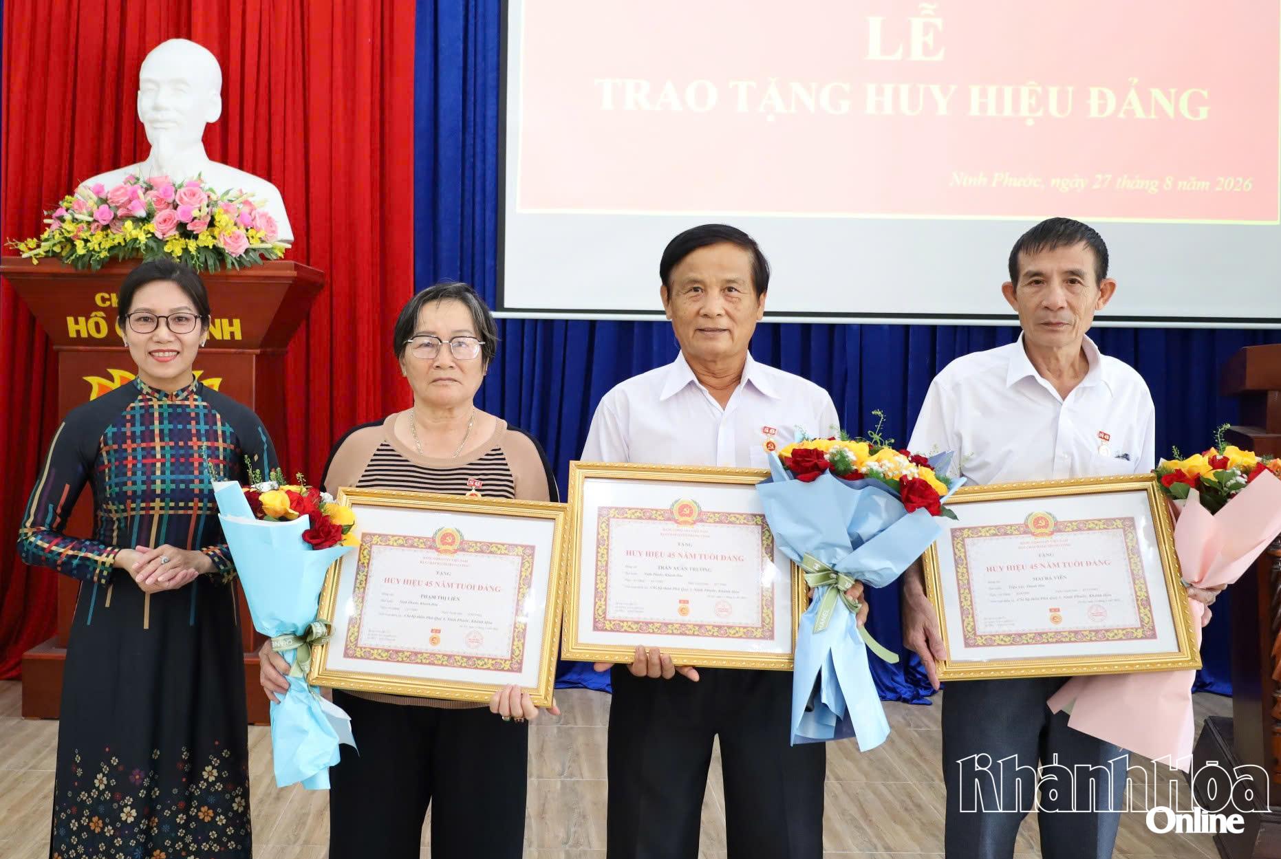 Thường trực Đảng ủy xã Ninh Phước trao Huy hiệu  năm tuổi Đảng và tặng hoa chúc mừng các đảng viên.