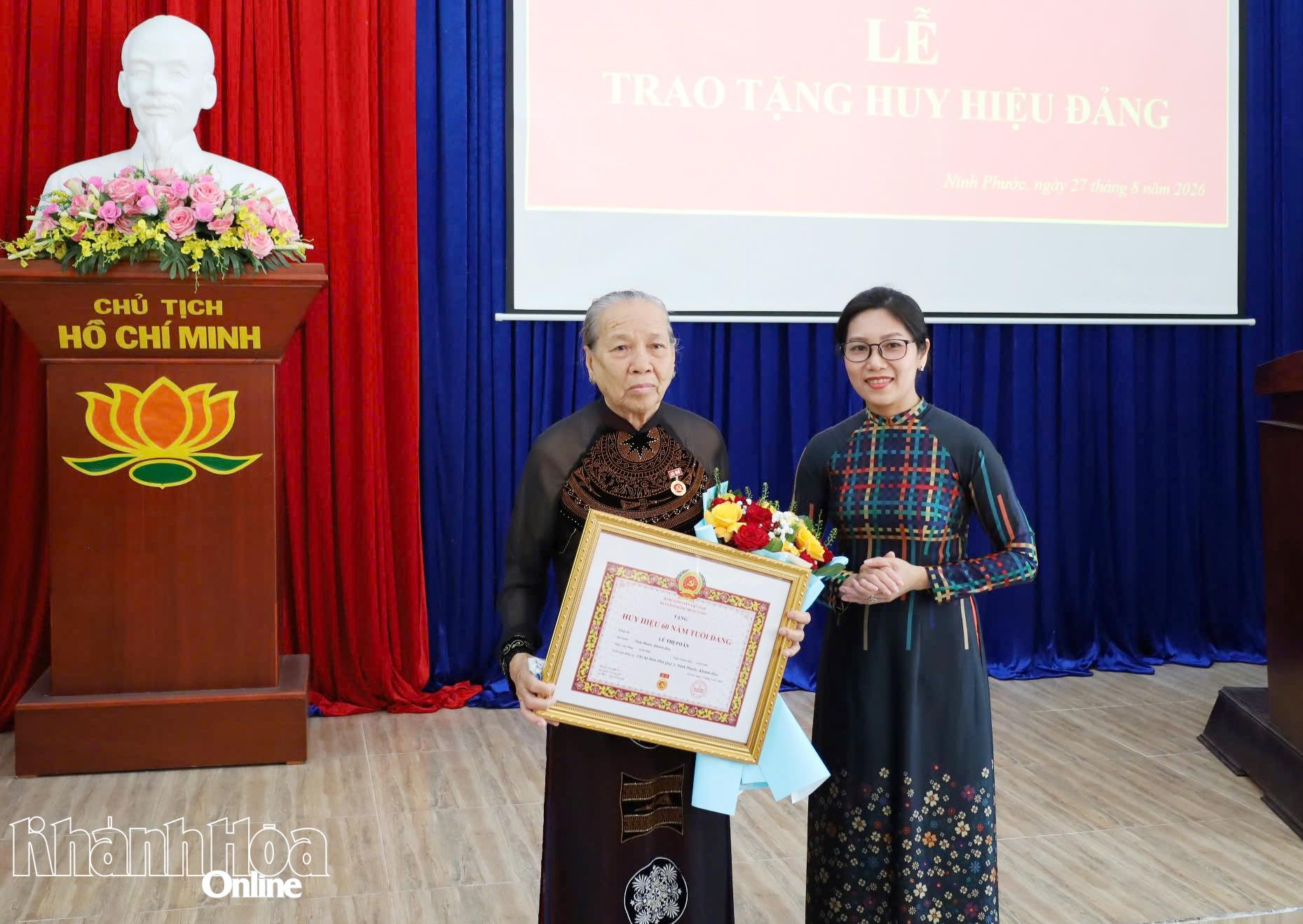 Thường trực Đảng ủy xã Ninh Phước trao Huy hiệu 60 năm tuổi Đảng và tặng hoa chúc mừng đảng viên Lê Thị Phân.