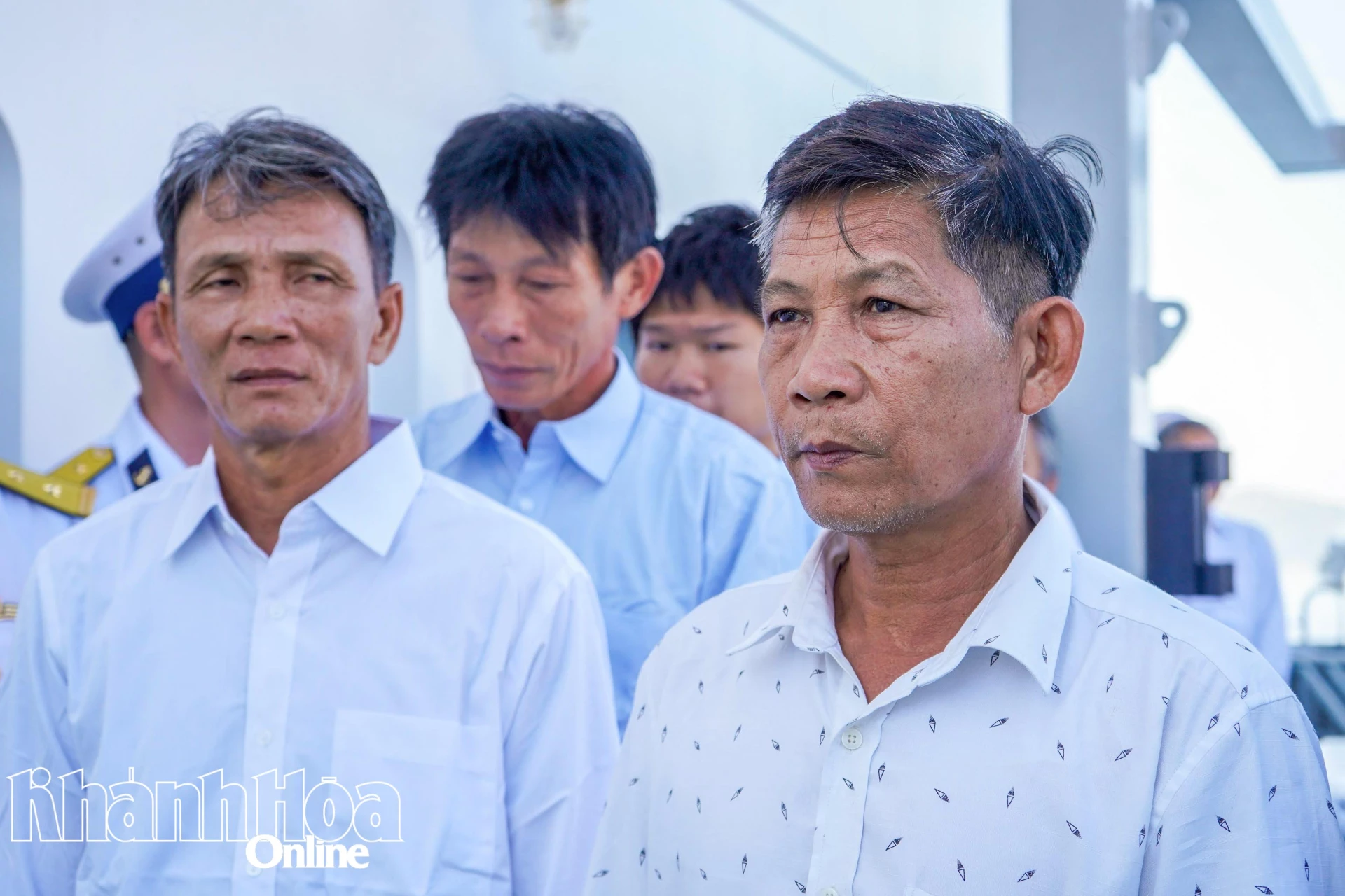 Ông Trần Văn Dân (bên phải), chủ tàu cá gặp nạn và các ngư dân trở về đất liền.