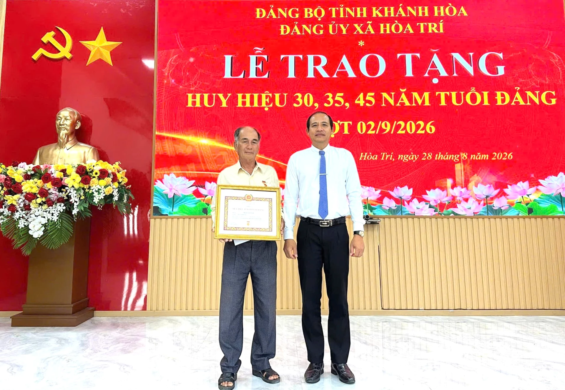 Ông Trần Văn Phải - Bí thư Đảng ủy, Chủ tịch HĐND xã trao Huy hiệu 45 tuổi Đảng cho ông Trần Văn Tạm - Chi bộ thôn Đồng Xuân.