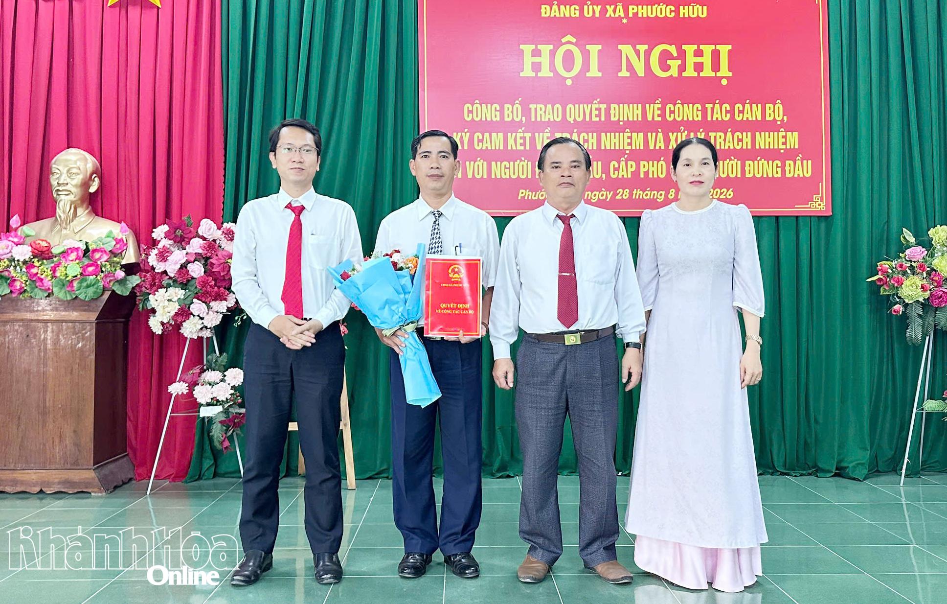 Thường trực Đảng ủy xã Phước Hữu trao quyết định và tặng hoa chúc mừng ông Phan Ngọc Thành.