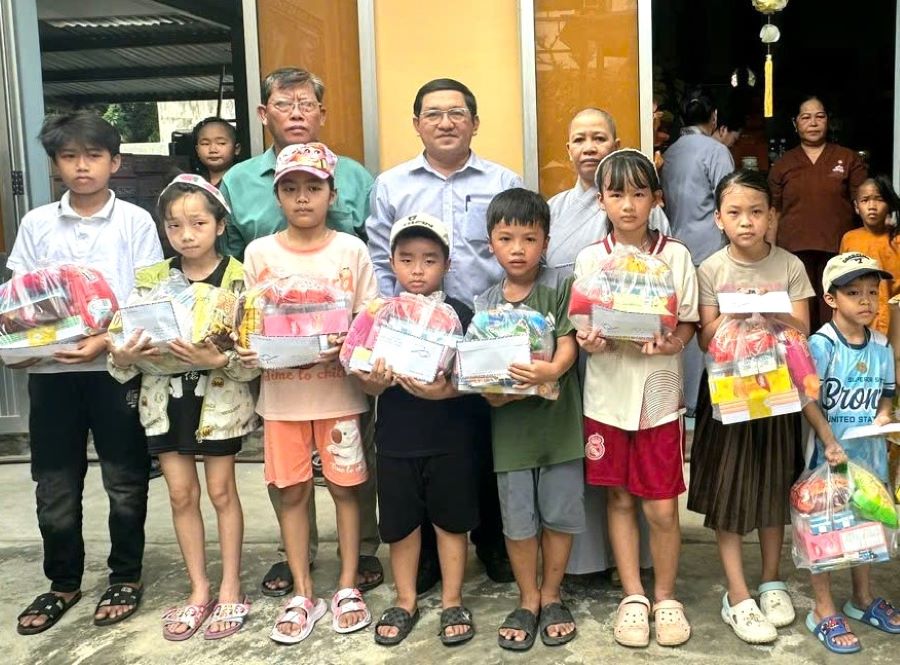Ban tổ chức trao quà cho trẻ em, học sinh có hoàn cảnh khó khăn.