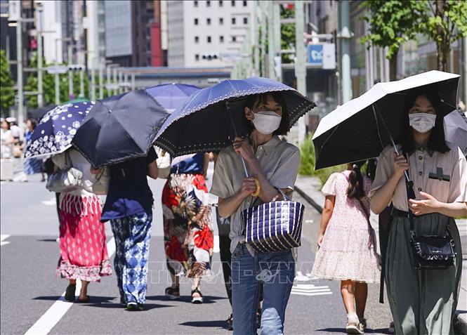 Người dân che ô tránh nắng nóng tại Tokyo, Nhật Bản, ngày 16/7/2023. Ảnh: Kyodo/TTXVN

