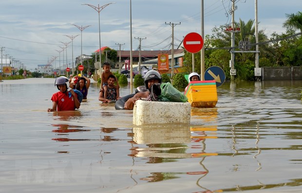 Người dân sơ tán khỏi các khu vực ngập lụt ở Phnom Penh, Campuchia. (Ảnh: AFP/TTXVN)

