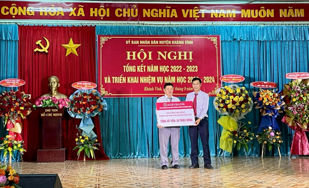 Đại diện Phòng Giáo dục và Đào tạo huyện Khánh Vĩnh (bìa trái) nhận biểu trưng tài trợ.