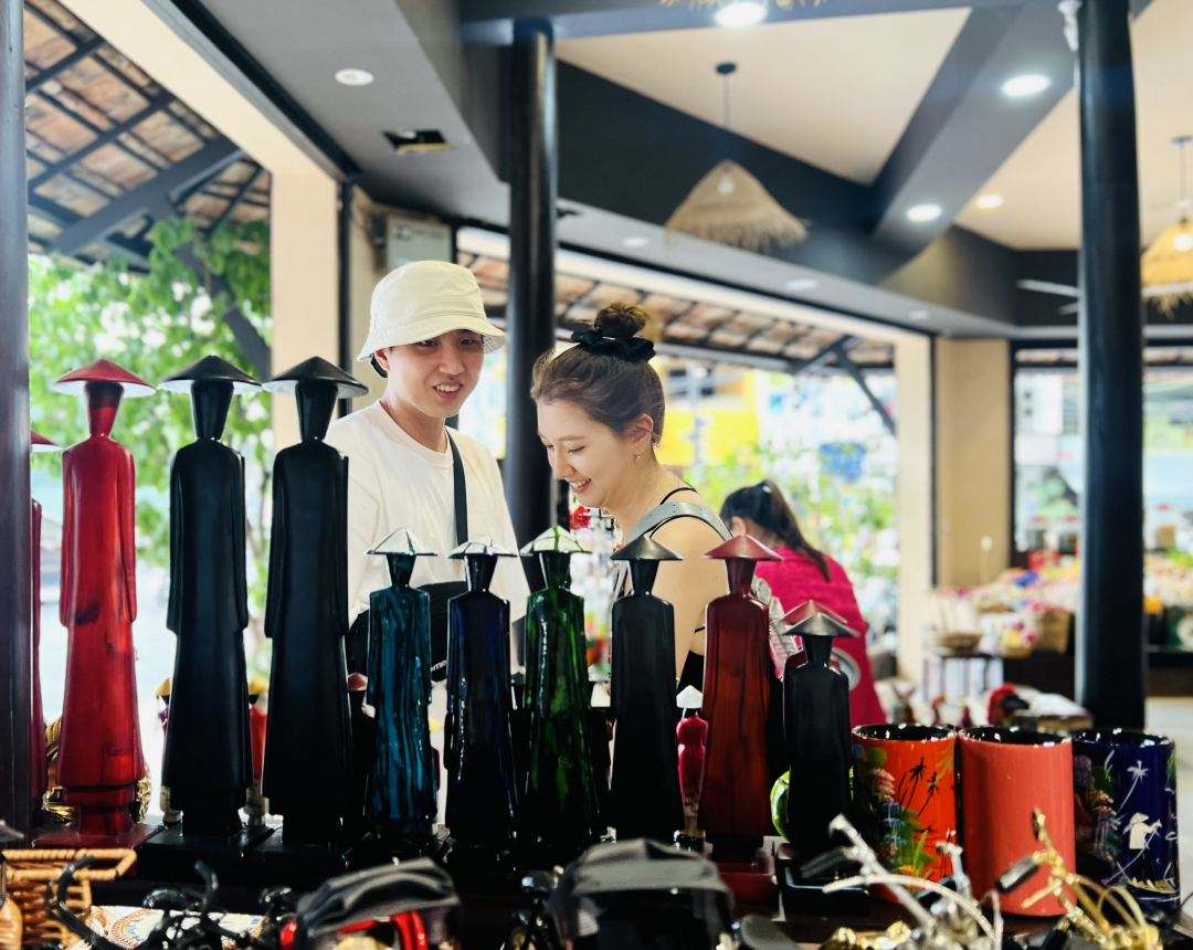Foreign tourists buy souvenirs at Ot Hiem shop in Nha Trang