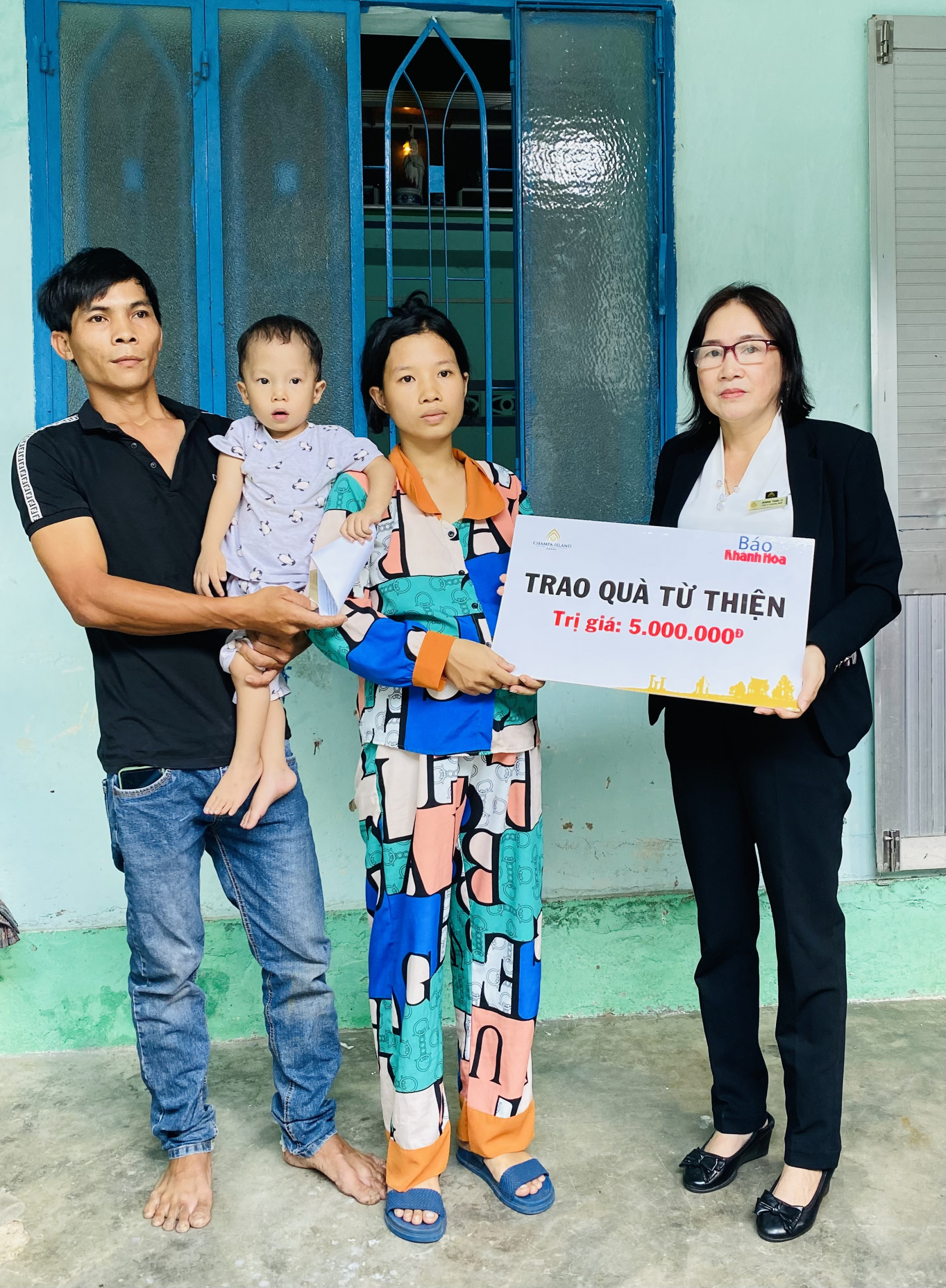 Đại diện Công ty Cổ phần Đầu tư Champagroup - Khu du lịch Champa Island Nha Trang trao tiền ủng hộ cho gia đình cháu Nguyễn Minh Quân