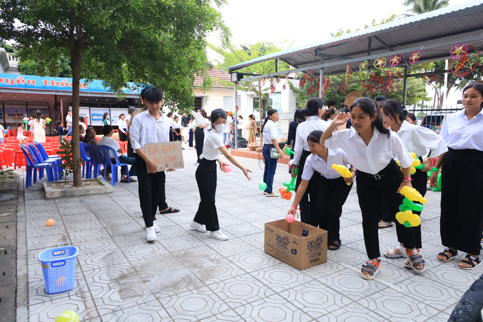 Các em nhỏ tham gia trò chơi ném bóng vào rổ.