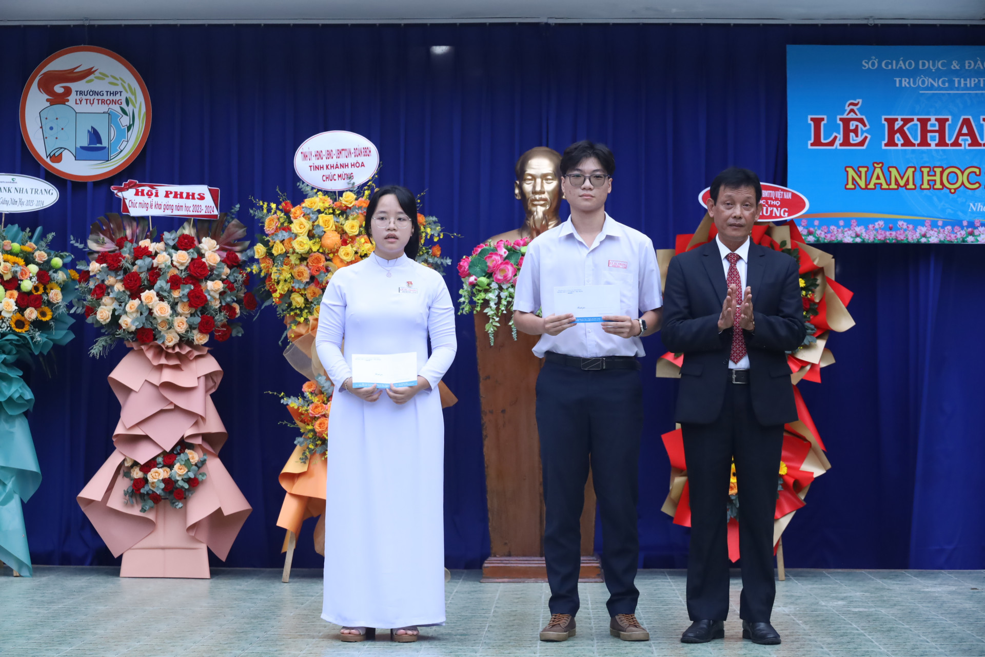 Hiệu trưởng Trường THPT Lý Tự Trọng trao thưởng cho hai học sinh
đạt kết quả thủ khoa tốt nghiệp THPT và thủ khoa đầu vào lớp 10 của trường.