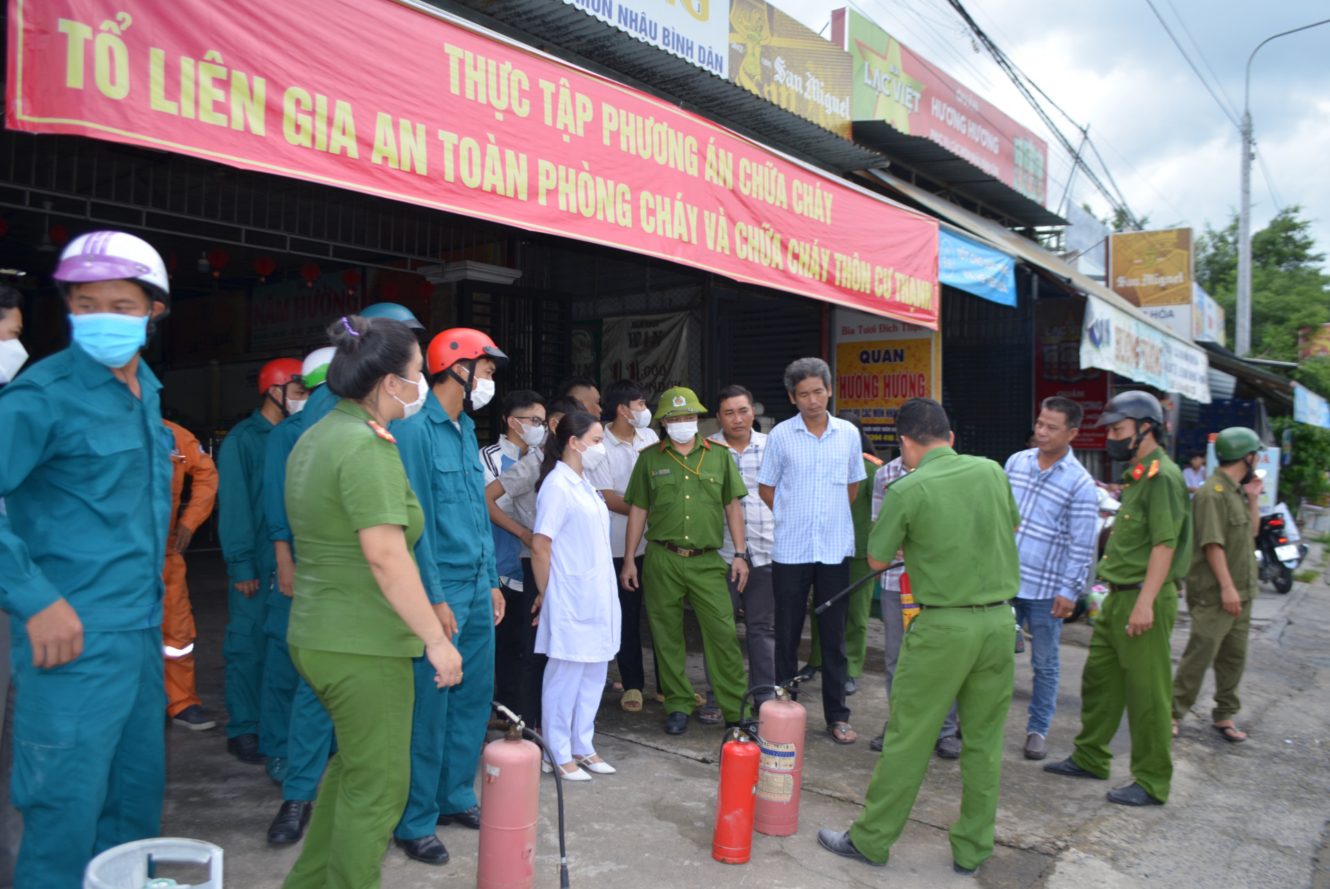 Công an huyện Diên Khánh hướng dẫn người dân sử dụng bình chữa cháy.