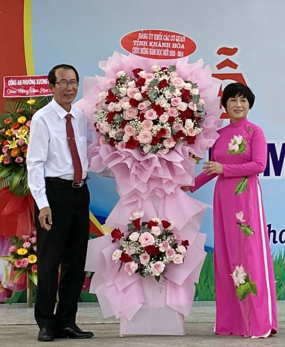 Bà Phạm Thị Khánh Hương trao tặng hoa chúc mừng nhà trường