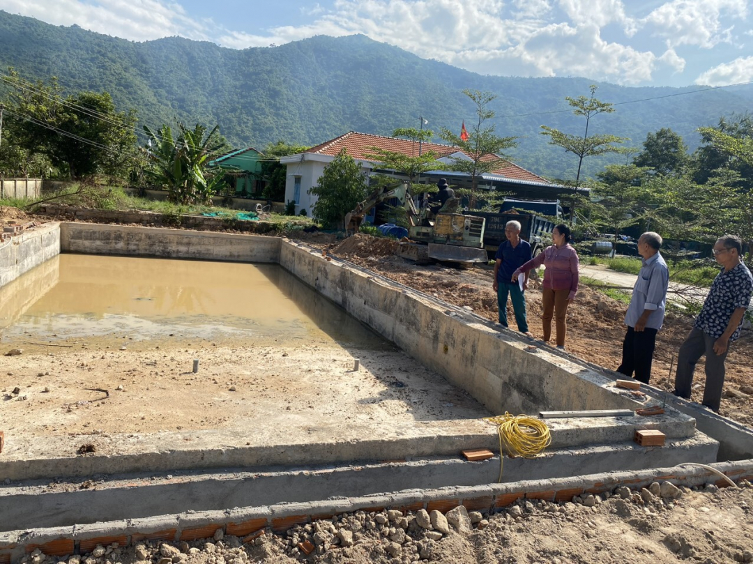 Các thành viên Ban Giám sát đầu tư cộng đồng giám sát công trình xây dựng hồ bơi trẻ em tại xã Xuân Sơn (huyện Vạn Ninh). 


