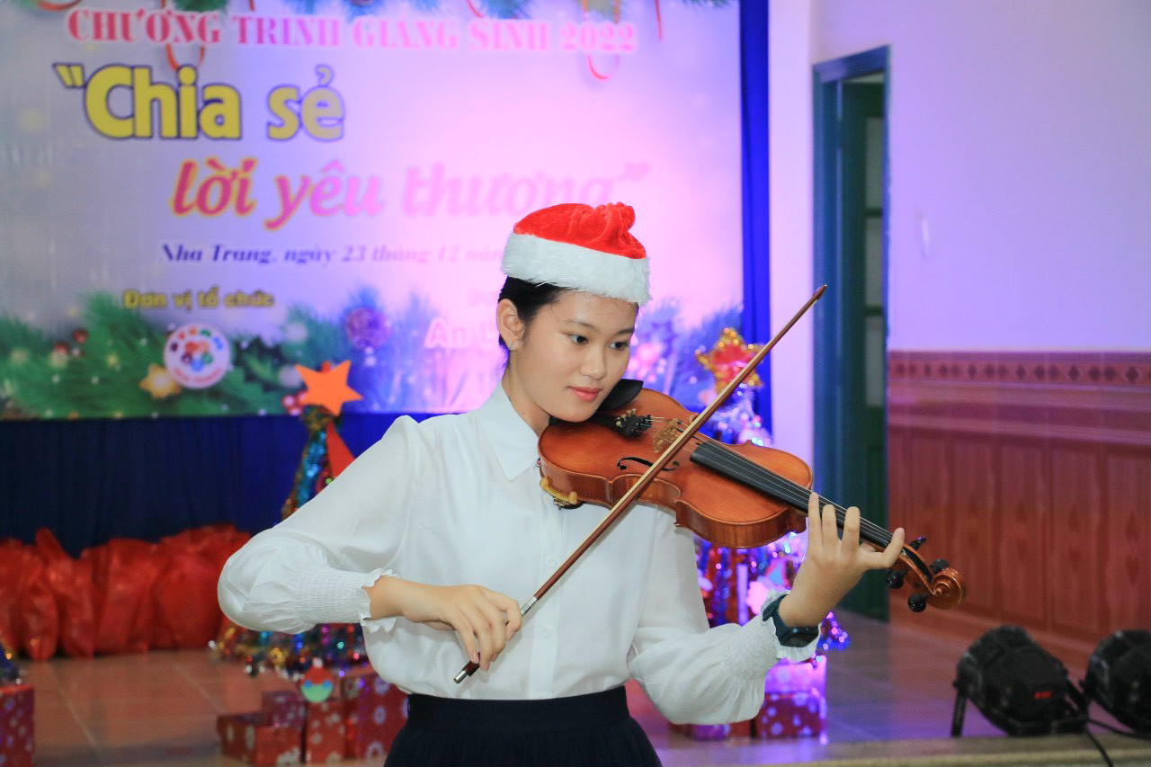 Đặng Cát Tiên biểu diễn đàn violin tại chương trình giáng sinh tổ chức cho các thiếu nhi Làng Trẻ em SOS Nha Trang.