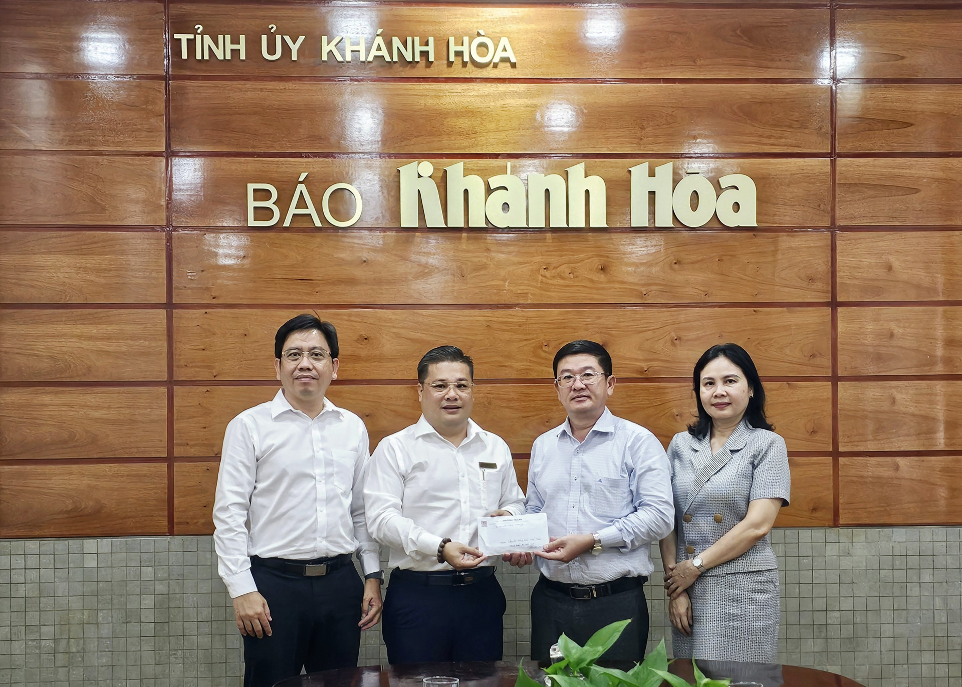 Đại diện Công ty Phương Trang - Chi nhánh Khánh Hòa trao tiền ủng hộ đồng bào bị ảnh hưởng do bão số 3 cho Báo Khánh Hòa.