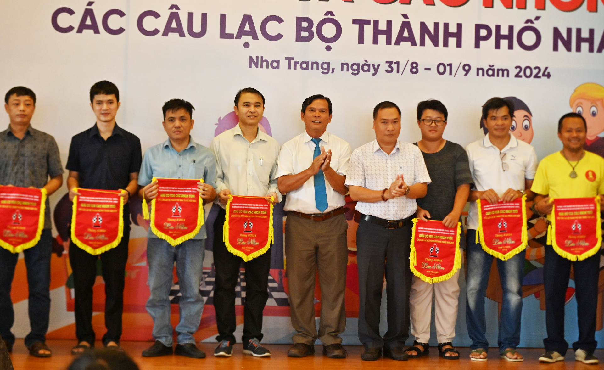 The organizers presenting souvenir flags to the participating teams

