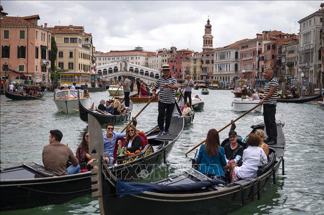 Khách du lịch đi thuyền gondola tại Venice, Italy. Ảnh minh hoạ: AFP/TTXVN

