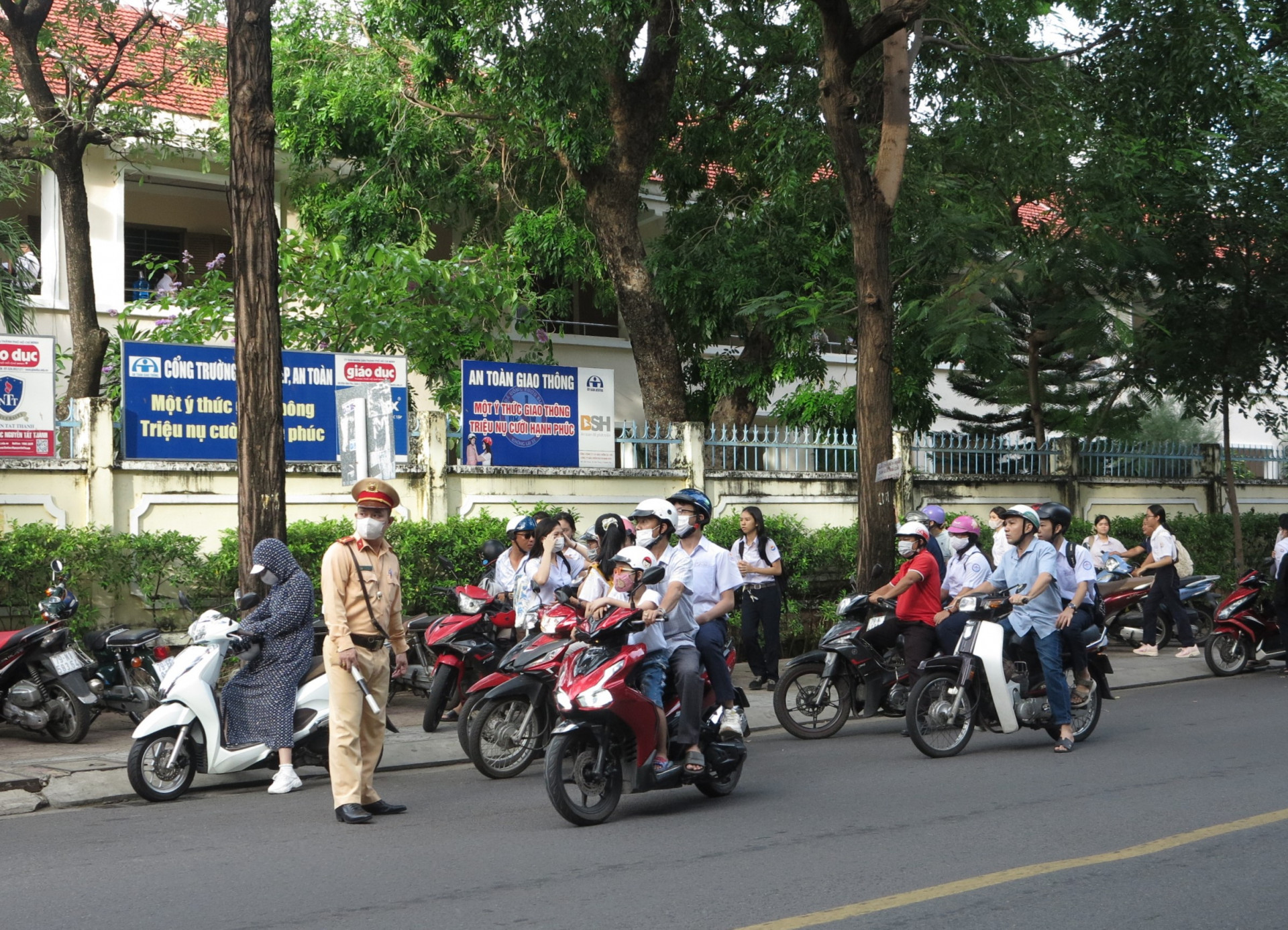 Cảnh sát giao thông điều tiết giao thông trước cổng trường. 