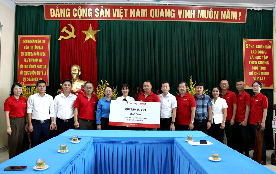 Giám đốc Chi nhánh Vietlott, chi nhánh Khánh Hòa, ông Nguyễn Duy Hiền, thành viên Quỹ Tâm Tài Việt (thứ 8, bên phải) trao tượng trưng thiết bị, dụng cụ học tập cho Trường THPT Ỷ La. Ảnh: Đức Minh