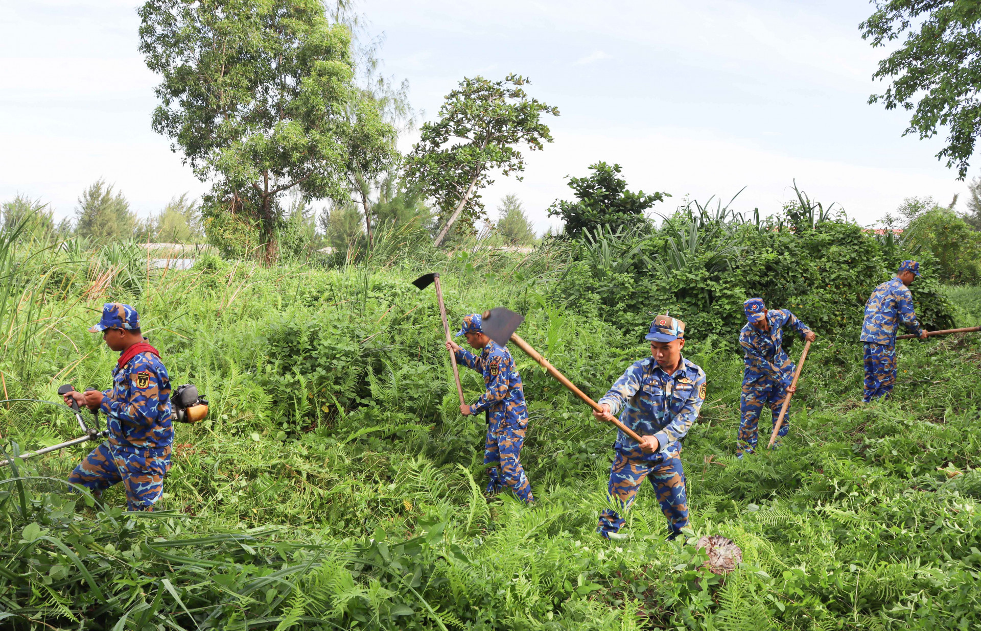 Các đoàn viên, thanh niên phát quang bụi rậm, cây cỏ.