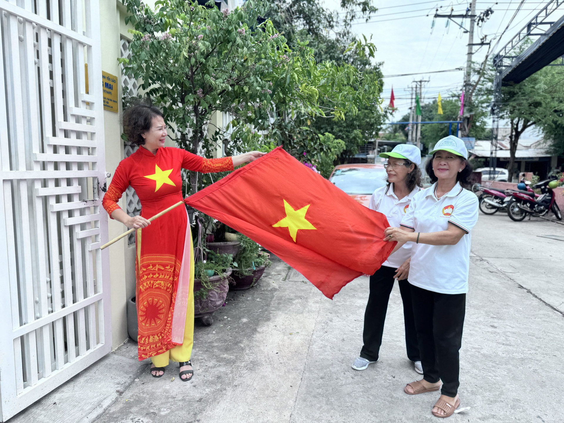 Cán bộ mặt trận hỗ trợ người dân treo cờ Tổ quốc tại đường 