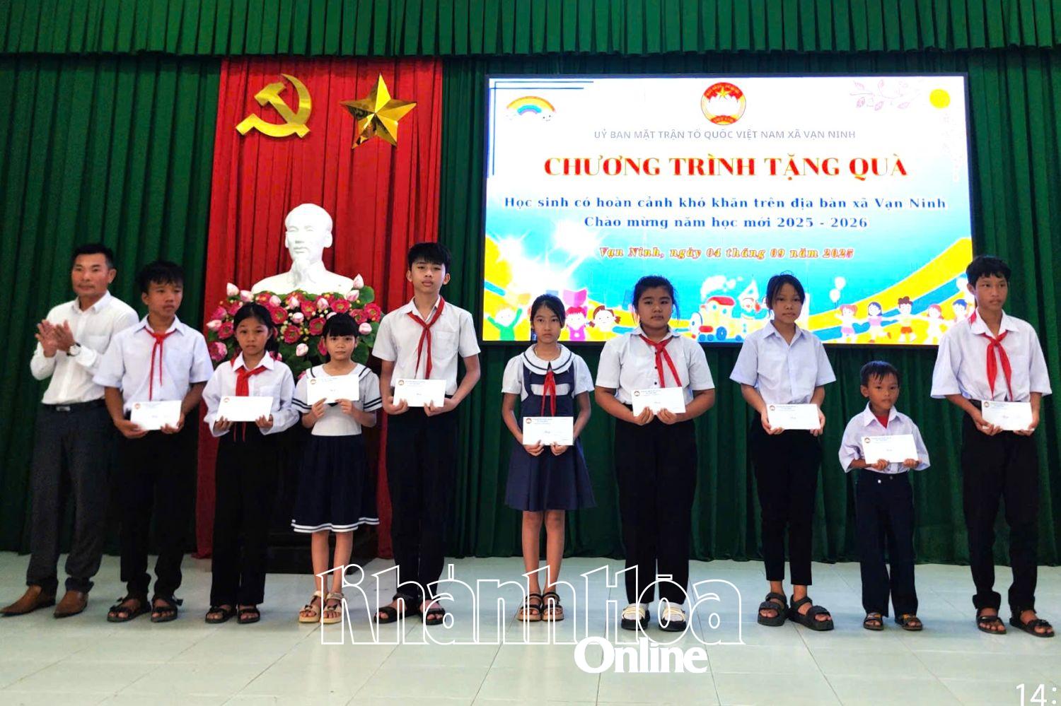 Đồng chí Lương Ngọc Minh –  Chủ tịch Ủy ban MTTQ Việt Nam xã Vạn Ninh trao quà cho các em học sinh.