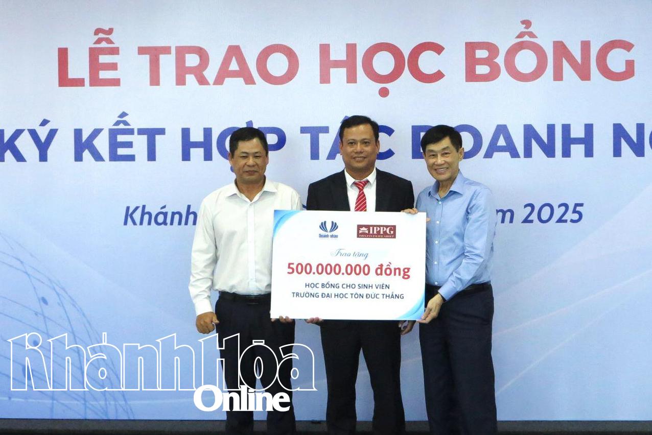 Đại diện Câu lạc bộ Doanh nhân Khánh Hòa - Sài Gòn và ông Johnathan Hạnh Nguyễn trao bảng tượng trưng học bổng cho Phân hiệu Trường Đại học Tôn Đức Thắng tại Khánh Hòa. 