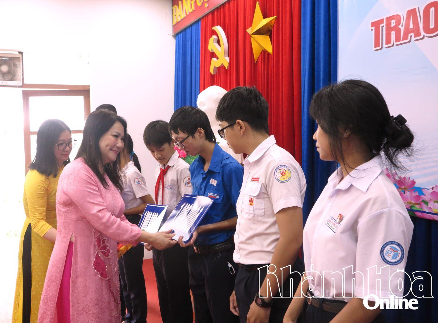 Đại diện doanh nghiệp trao học bổng cho các học sinh, sinh viên.