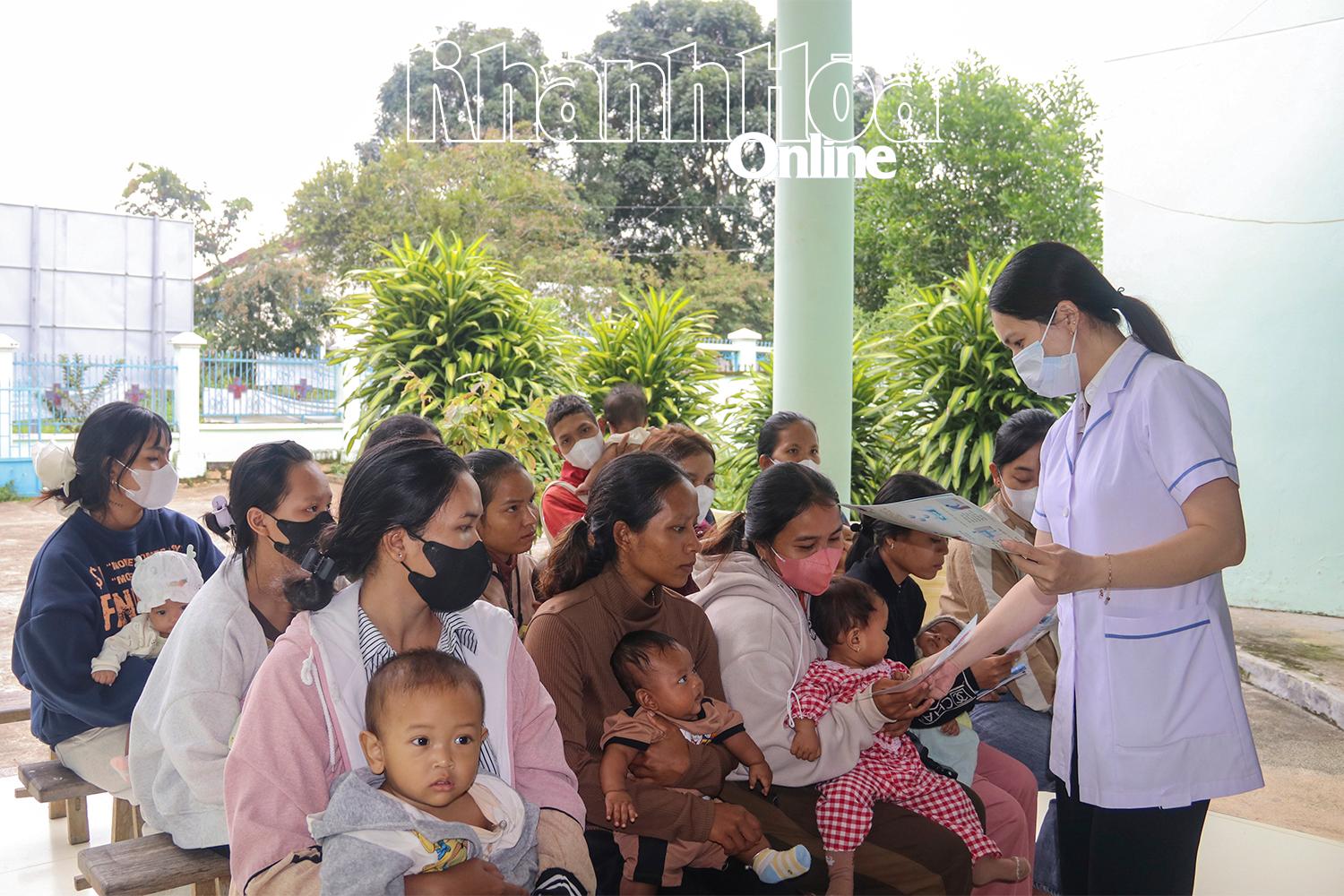 Cán bộ Trạm Y tế Sơn Hiệp (xã Khánh Sơn) phát tờ rơi tuyên truyền chăm sóc sức khỏe cho phụ nữ và trẻ em.
