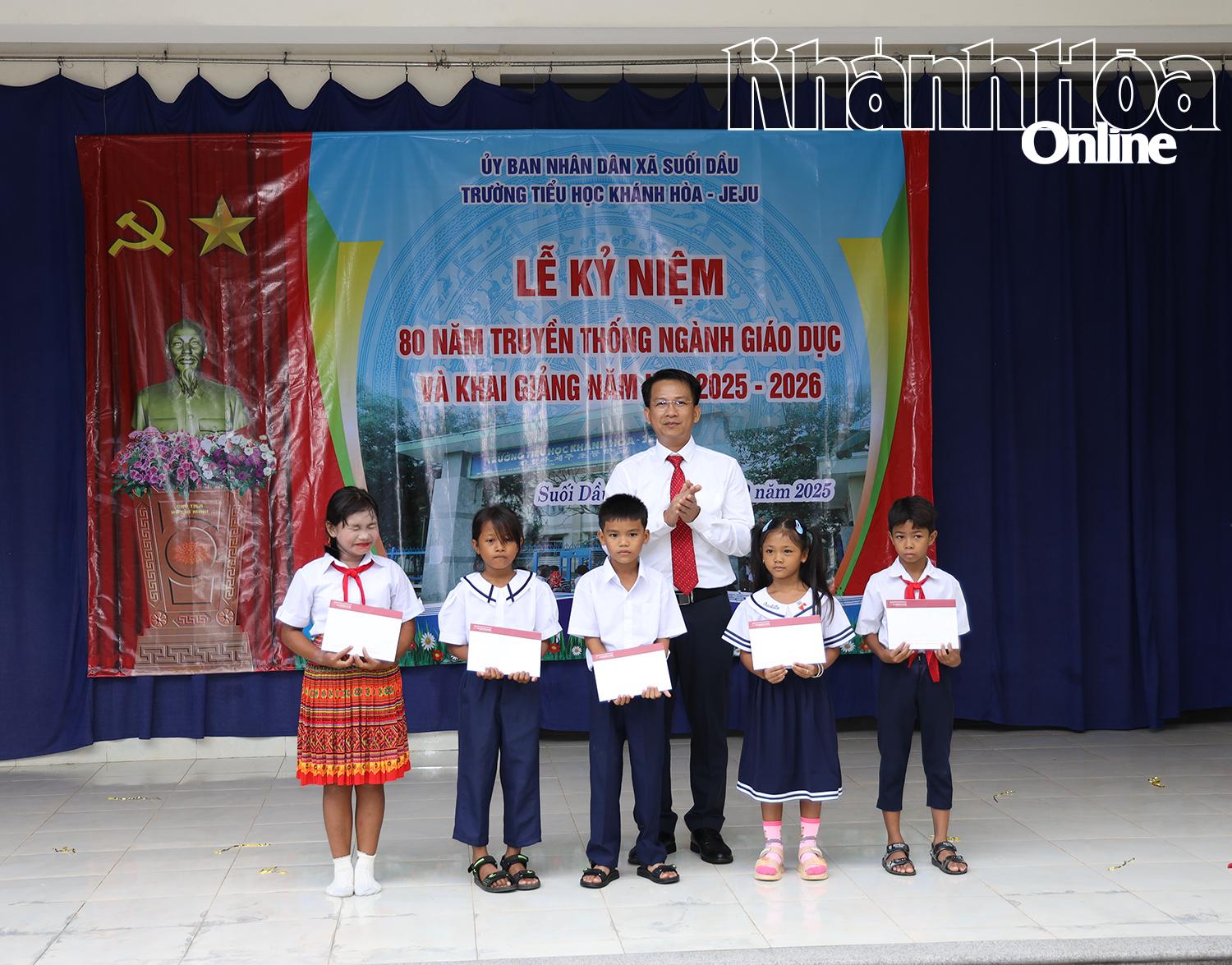 Đại diện lãnh đạo xã Suối Dầu trao học bổng của Agribank Khánh Hòa cho các em học sinh.