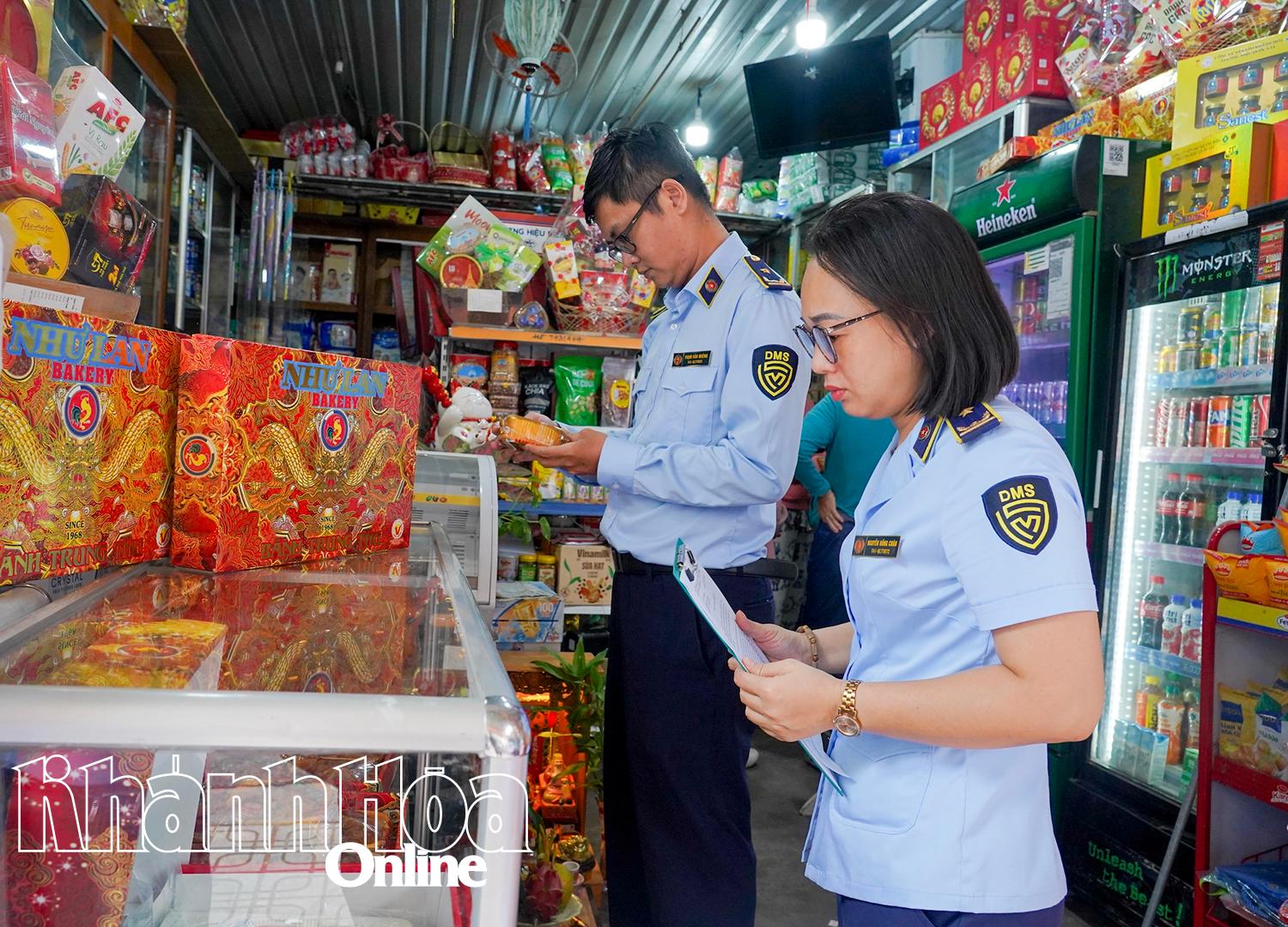 Cán bộ Đội Quản lý thị trường số 1 kiểm tra hàng hóa tại một cửa hàng tạp hóa trên đường Quang Trung (phường Nha Trang).