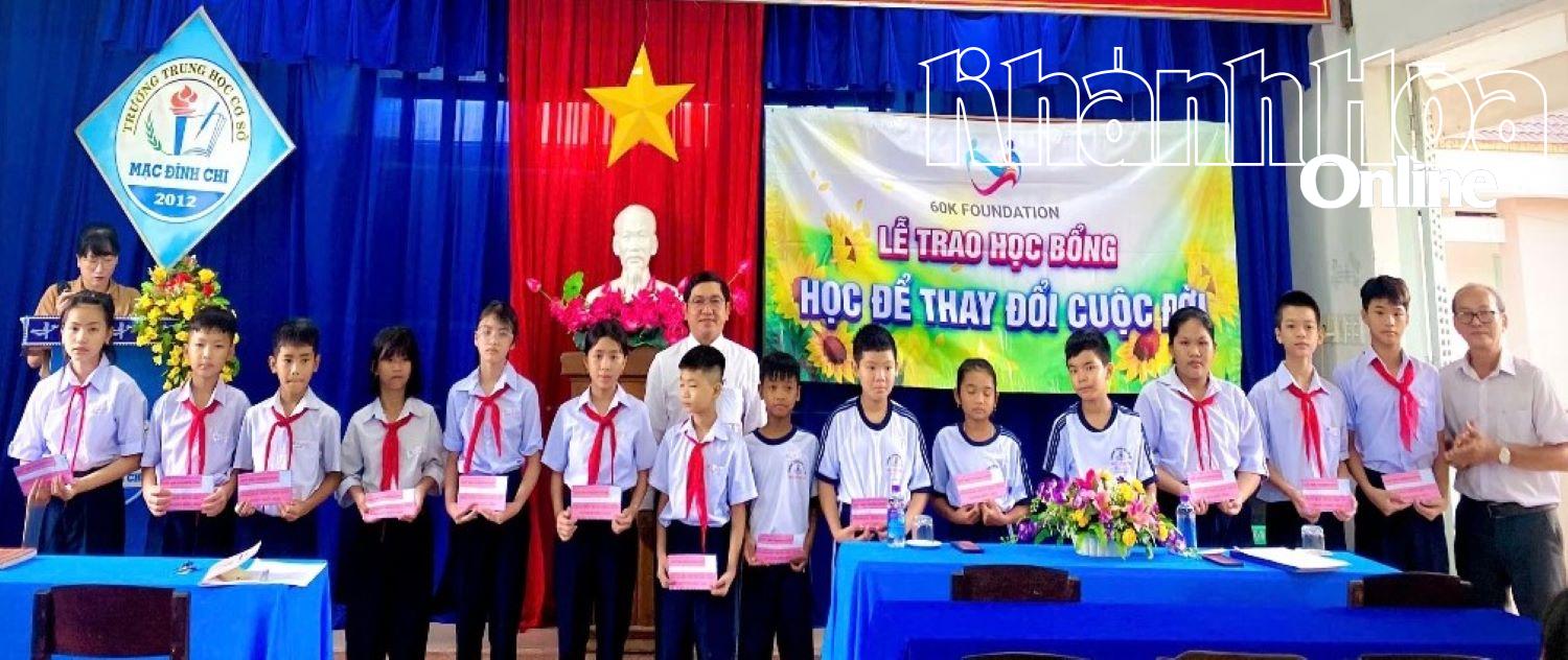 Đại diện Quỹ 60K Foundation và Trường THCS Mạc Đĩnh Chi trao học bổng cho học sinh có hoàn cảnh khó khăn.