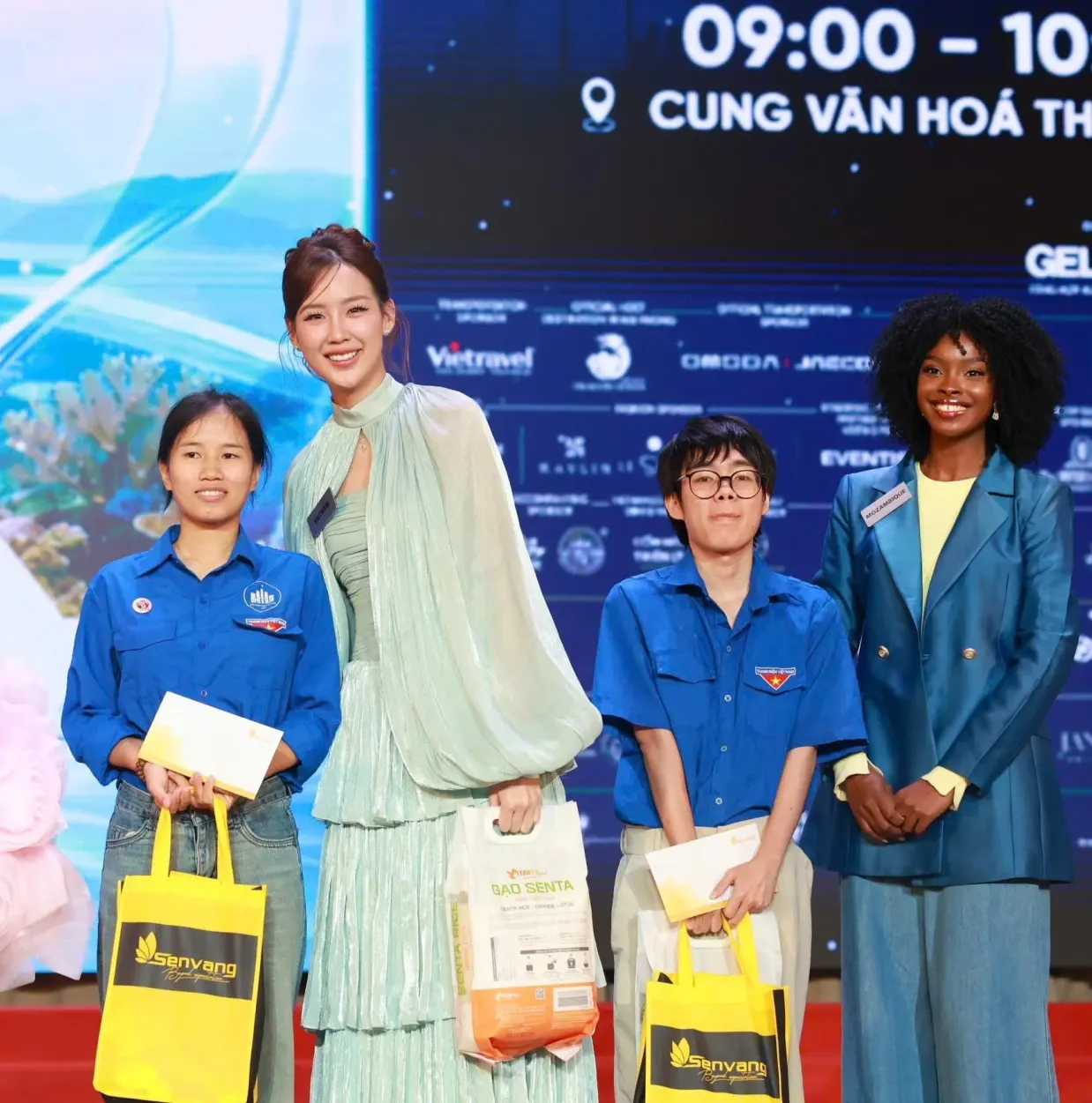 Vietnams representative Le Nguyen Bao Ngoc and fellow contestants present gifts to students