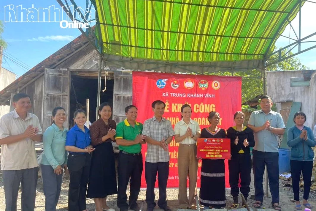 Đại diện cấp ủy, chính quyền và Mặt trận địa phương trao bảng tượng trưng số tiền hỗ trợ xây dựng nhà cho gia đình.