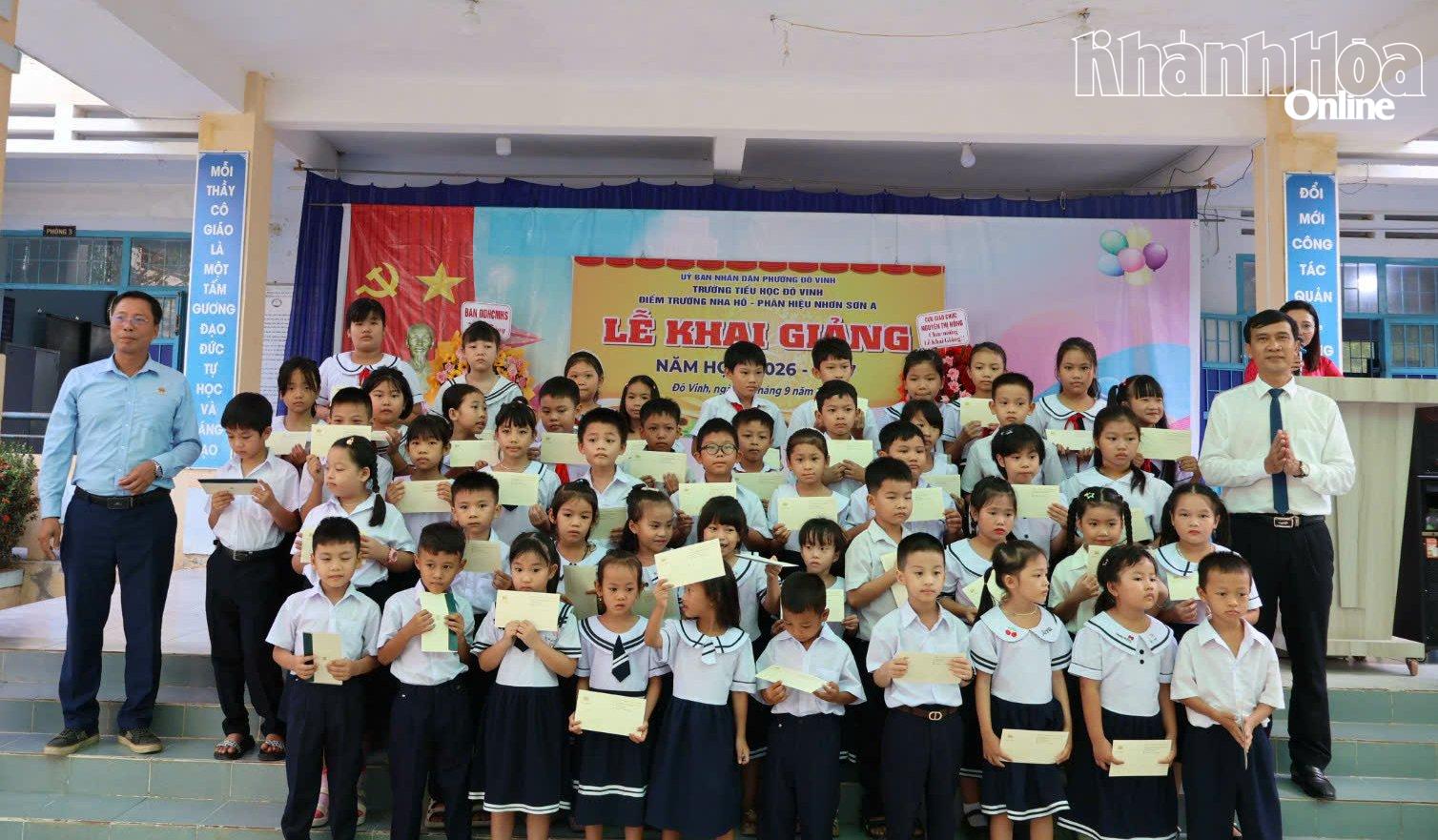 Lãnh đạo địa phương và Công ty MK trao quà cho các em học sinh.