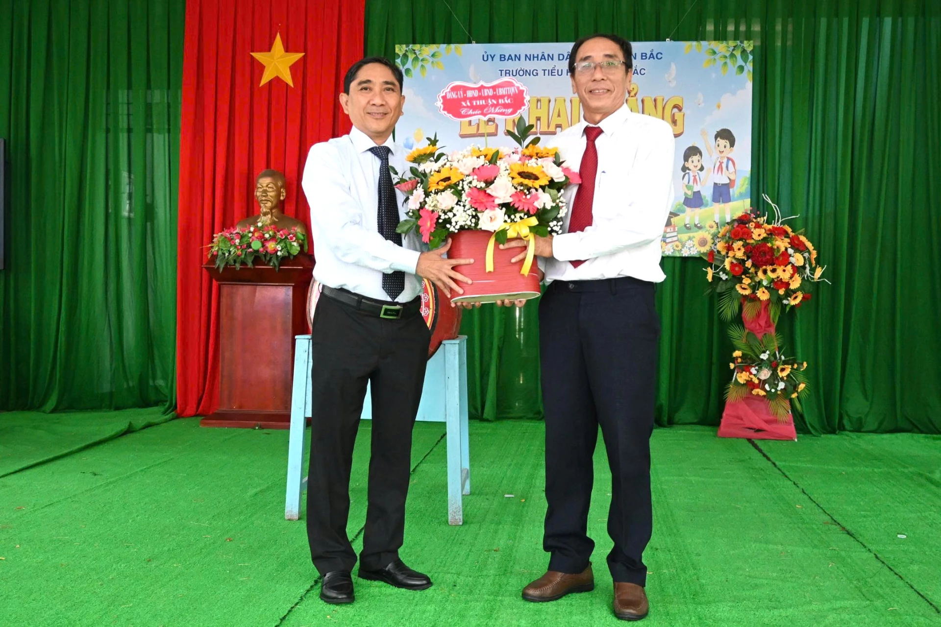 ông Hồ Sĩ Sơn, Bí thư Đảng uỷ, Chủ tịch HĐND xã tặng hoa chúc mừng các cán bộ, giáo viên của Trường Tiểu học Thuận Bắc.