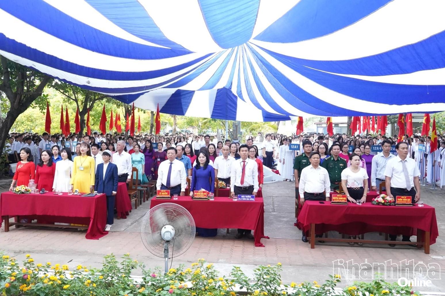 Đồng chí Lê Huyền, các đại biểu, thầy cô giáo và các em học sinh trường THPT Chu Văn An thực hiện nghi thức chào cờ. 