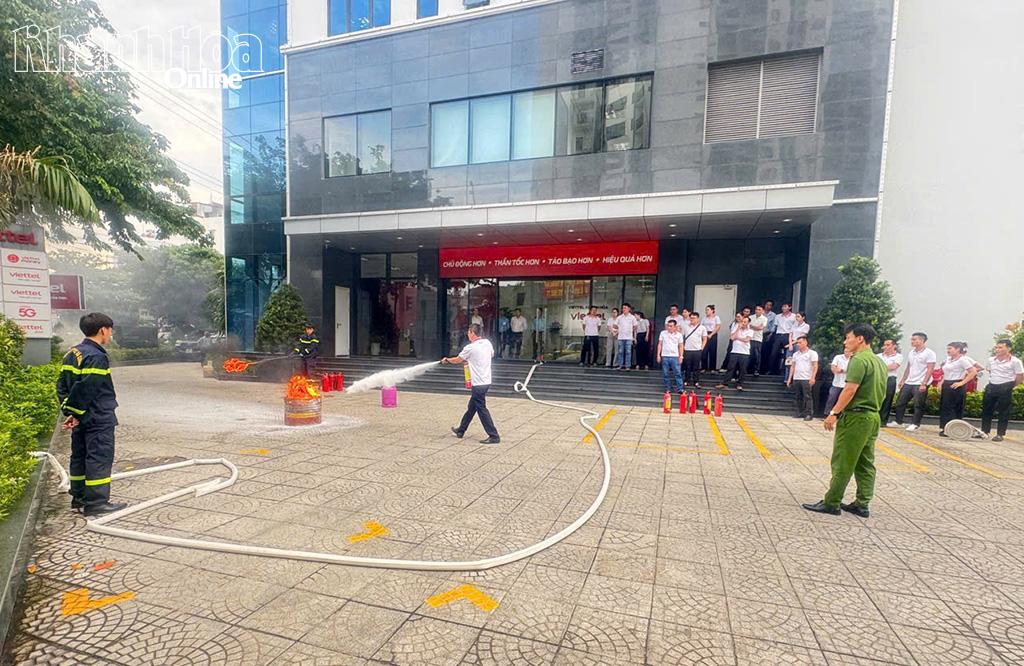 Các học viên thực hành dập lửa bằng bình chữa cháy xách tay.