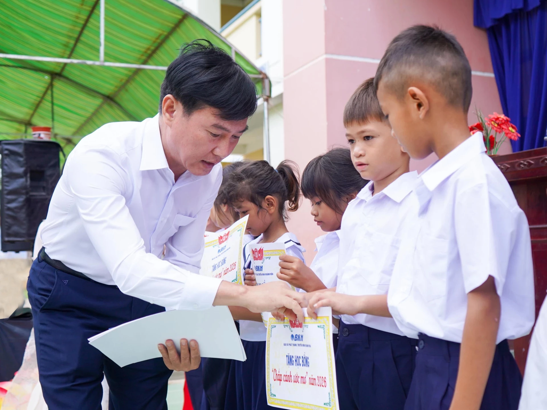 Ông Trần Văn Thanh - Phó Giám đốc Báo và Phát thanh, Truyền hình Khánh Hòa trao học bổng cho các học sinh.