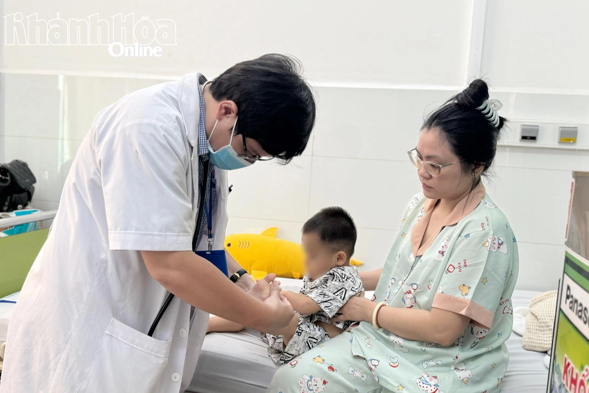 Bác sĩ Bệnh viện Bệnh nhiệt đới Khánh Hòa kiểm tra sức khỏe cho trẻ mắc bệnh tay chân miệng. 