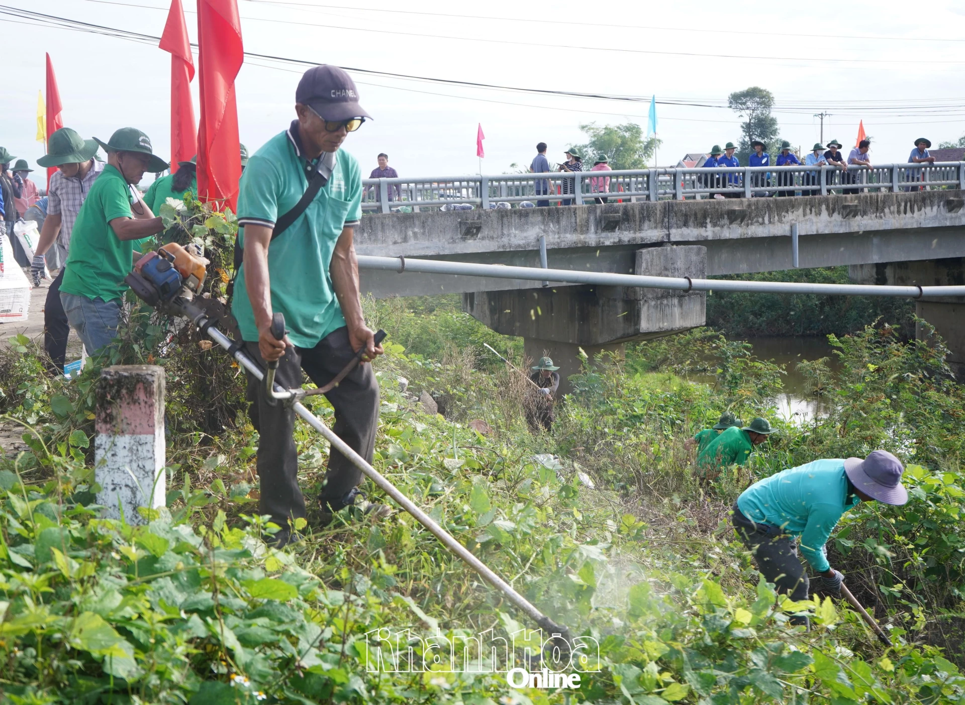 Người dân xã Hòa Trí cắt bỏ cây bụi dọc bờ sông Tân Lâm.