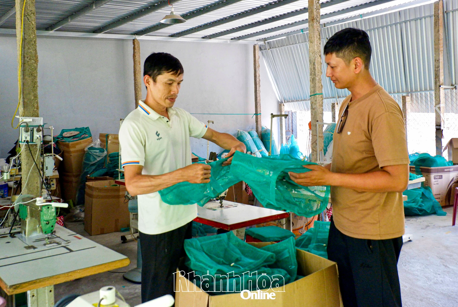 Anh Phạm Huỳnh Minh Tuấn (bên phải) trao đổi công việc tại xưởng sản xuất túi.