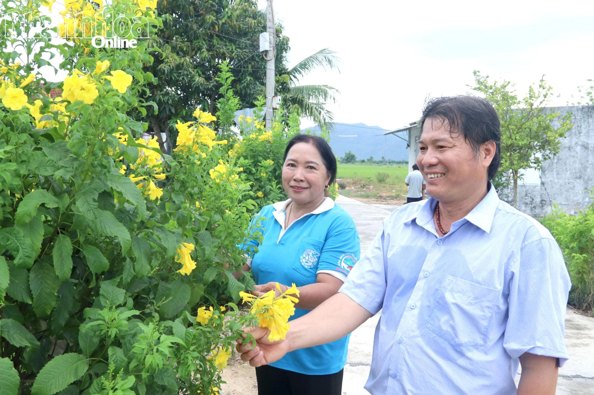 Ông Nguyễn Quang Minh cùng 
đại diện Chi hội Phụ nữ thôn Lạc Lợi trao đổi về việc duy trì cây xanh, hoa trên tuyến đường xanh - sạch - đẹp.
