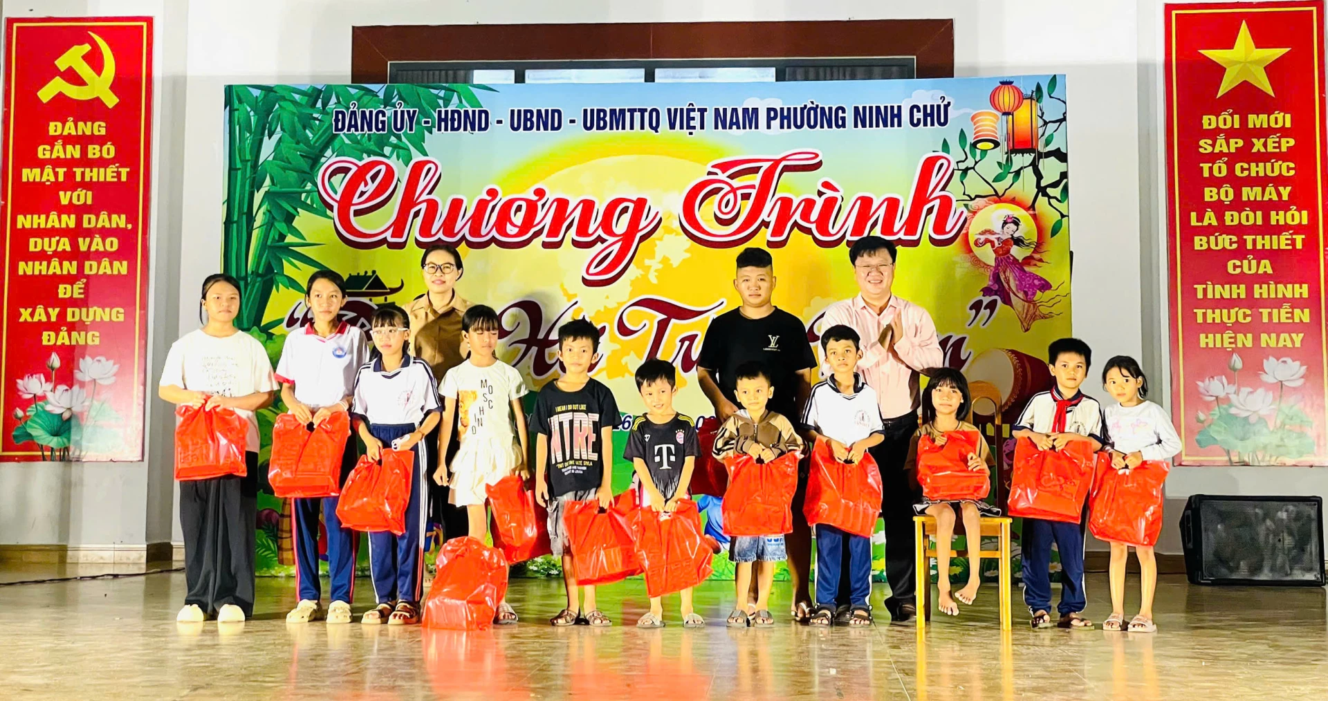Lãnh đạo UBND phường Ninh Chử trao quà cho trẻ em.