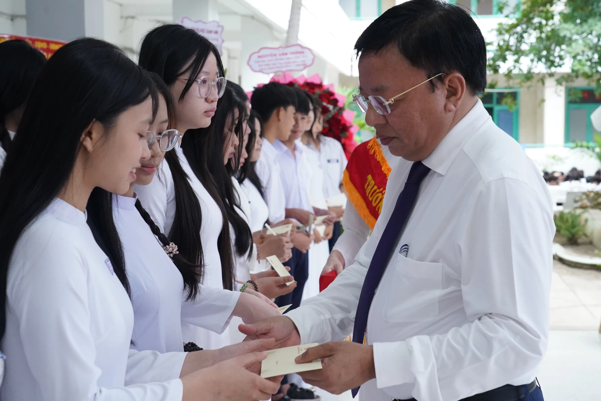 Đồng chí Lê Huyền trao quà cho các em học sinh.