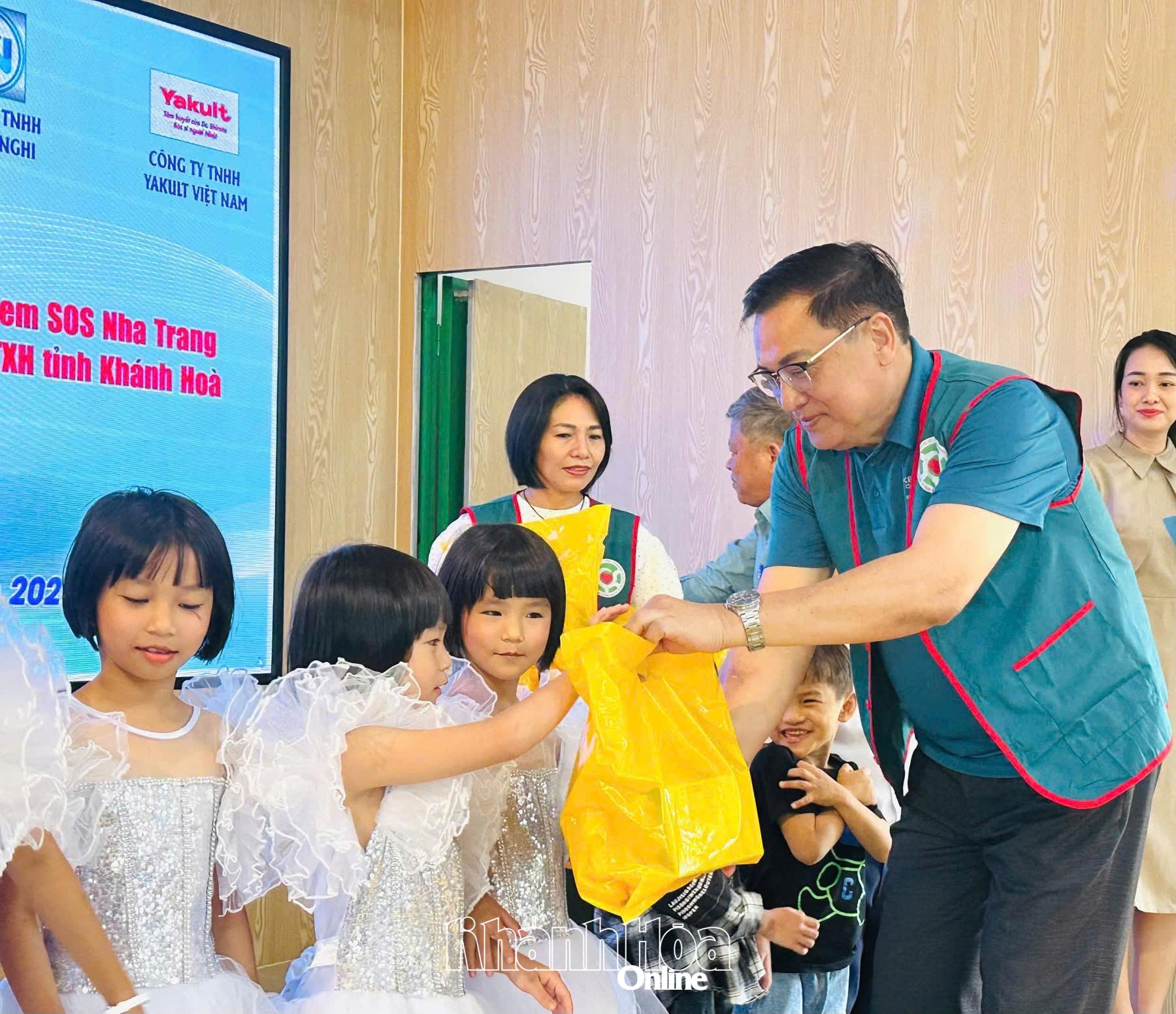 Tiến sĩ Lê Hữu Thọ - Chủ tịch Hội Bảo trợ người khuyết tật, bệnh nhân nghèo và quyền trẻ em tỉnh tặng quà cho trẻ em tại Làng Trẻ em SOS Nha Trang.